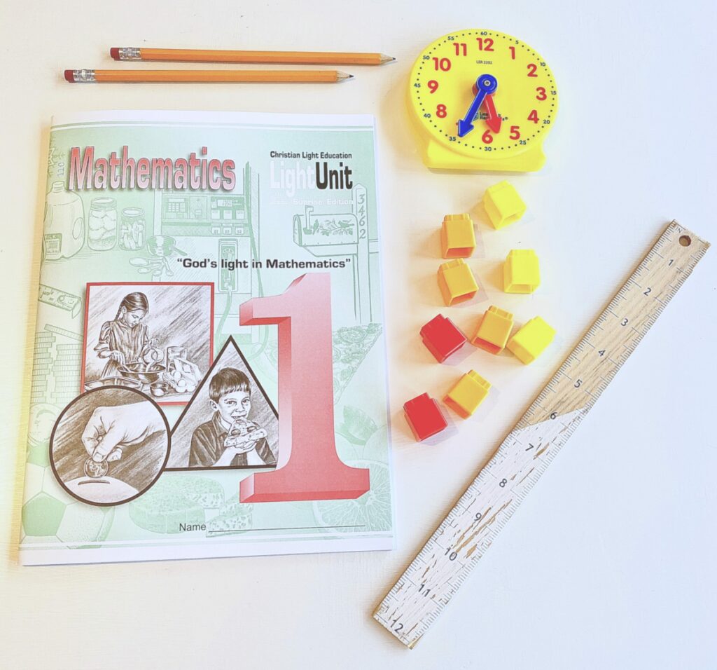 Christian Light Education Math Unit book used for first grade, unifix cubes, and a ruler