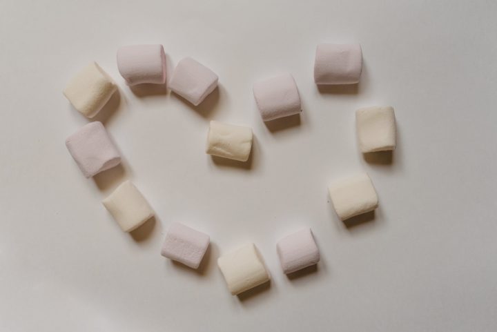 sweet marshmallows arranged on table in shape of heart