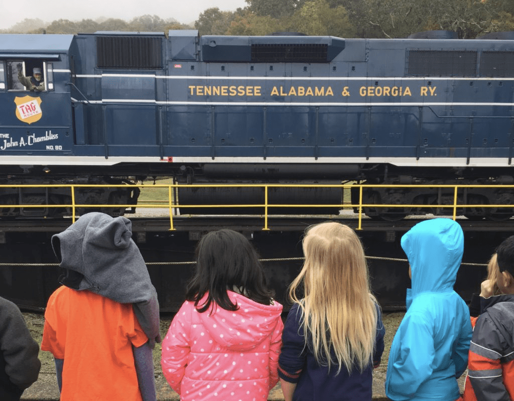 Children looking at a train car on a field trip to the train station.