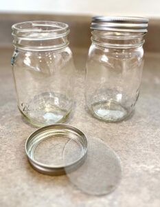 16 ounce mason jars, metal ring, and a splash screen are used to make jars for sprouting the wheat berries.