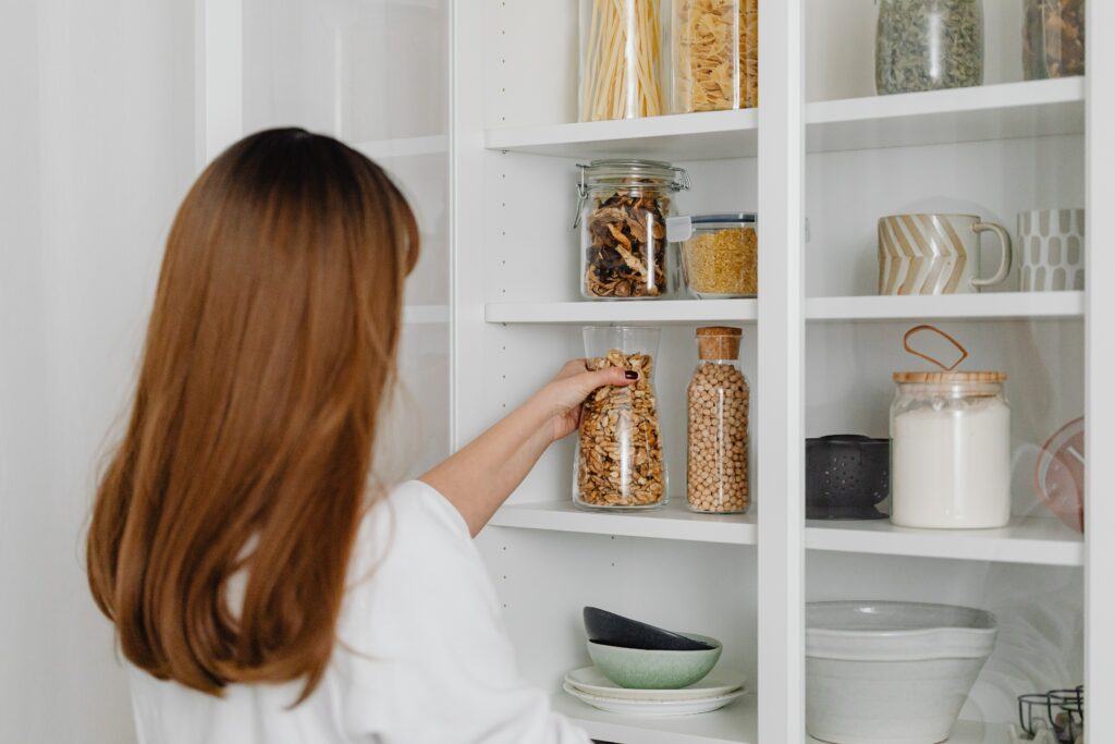 A woman is ADHD meal planning by looking at all the items in her pantry first.